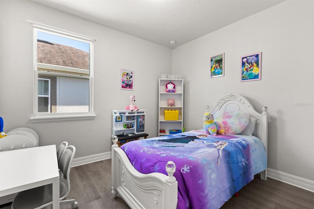 2417 Chateau Loop Kissimmee, FL 34741 - Photo 11 of 16 a bedroom with a bed and wooden floor