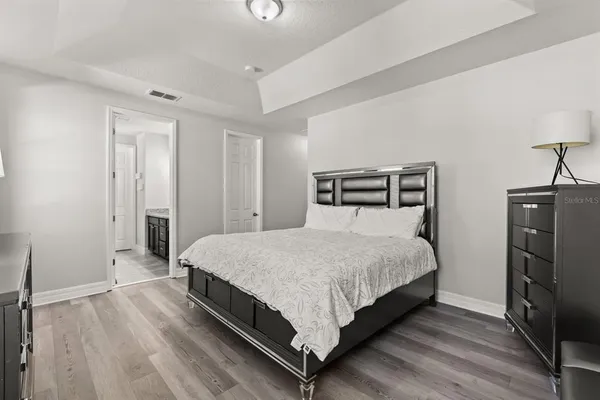 a bedroom with a bed and wooden floor