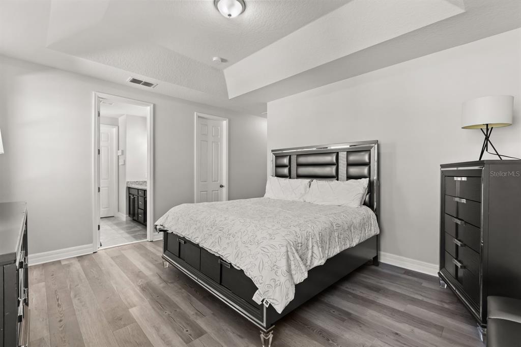 2417 Chateau Loop Kissimmee, FL 34741 - Photo 12 of 16 a bedroom with a bed and wooden floor