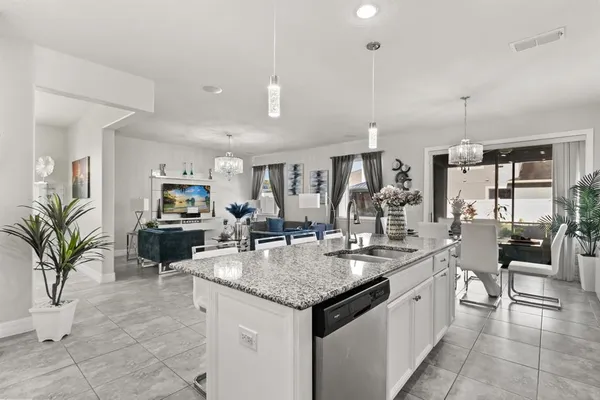 a kitchen with granite countertop a sink a counter top space and living room view