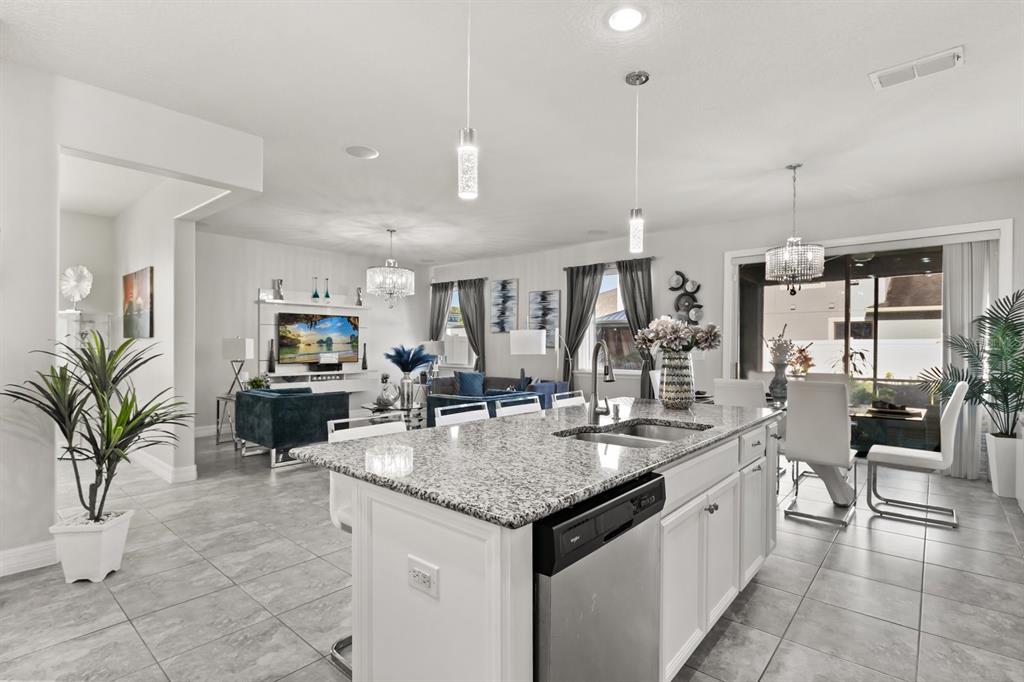 2417 Chateau Loop Kissimmee, FL 34741 - Photo 5 of 16 a kitchen with granite countertop a sink a counter top space and living room view
