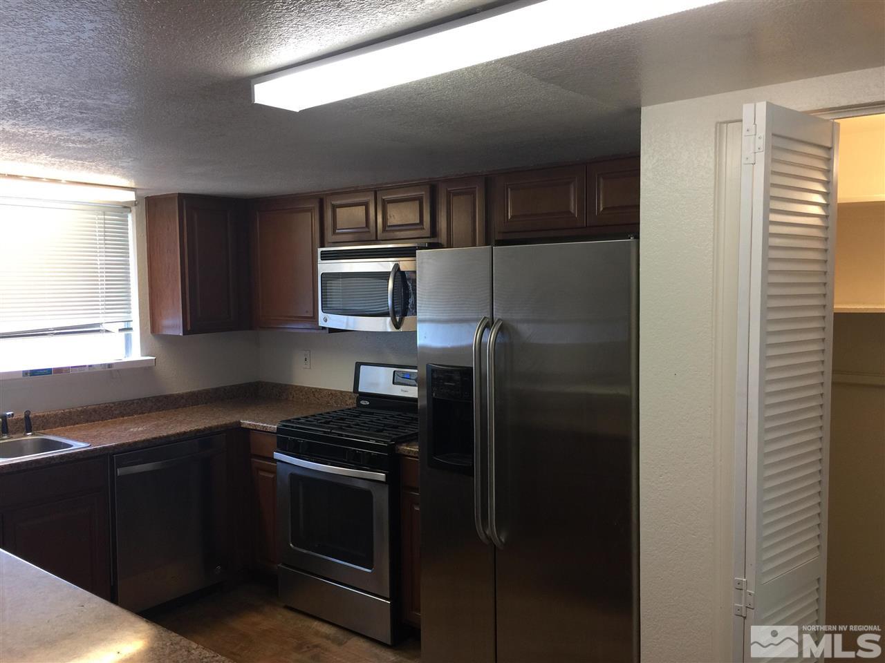 10030 Humite Lane Reno, NV 89506 - Photo 5 of 12 a kitchen with a refrigerator stove and sink