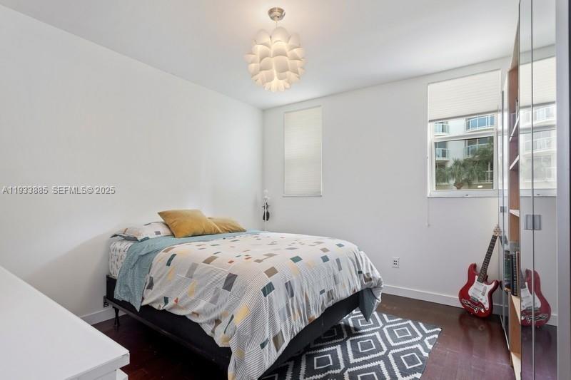 8888 Collins Avenue, Unit 115 Surfside, FL 33154 - Photo 11 of 18 a bedroom with a bed and a chandelier