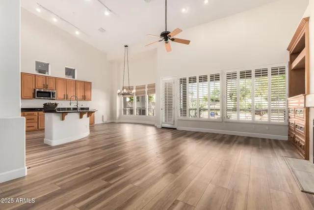 a view of a kitchen with kitchen island wooden floors appliances and cabinets