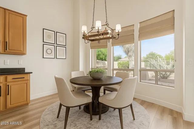 a dining room with furniture a chandelier and wooden floor