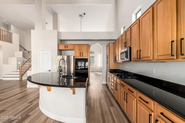 a kitchen with stainless steel appliances granite countertop a sink a stove and a refrigerator