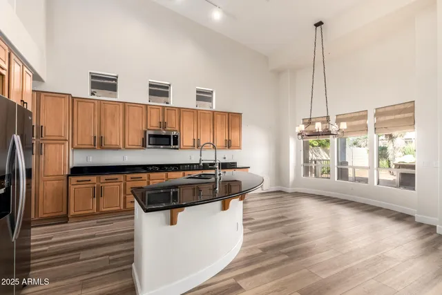 a kitchen with stainless steel appliances granite countertop a stove a sink and a refrigerator