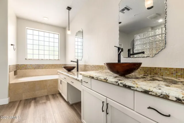 a bathroom with a granite countertop sink a toilet and bathtub