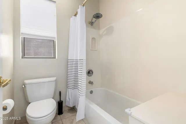 a white toilet sitting next to a bath tub