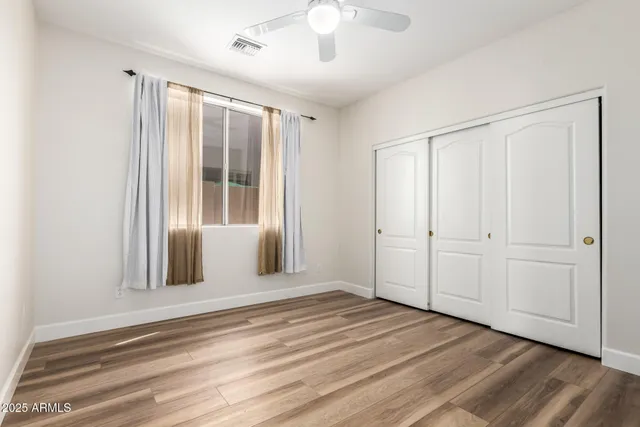a view of a livingroom with wooden floor and a window