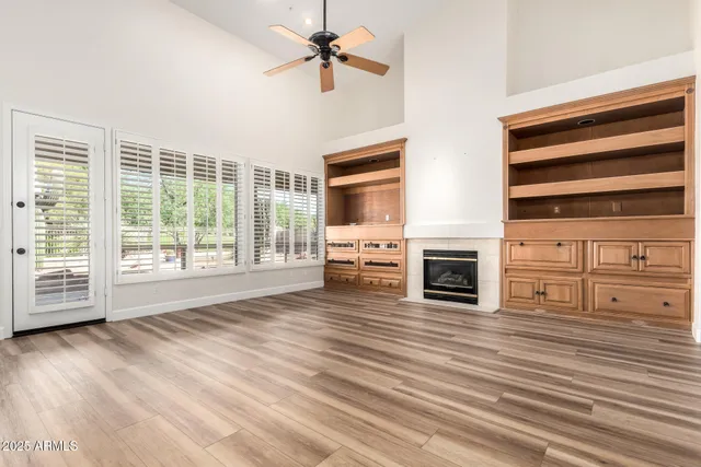 a view of a livingroom with wooden floor a fireplace and window