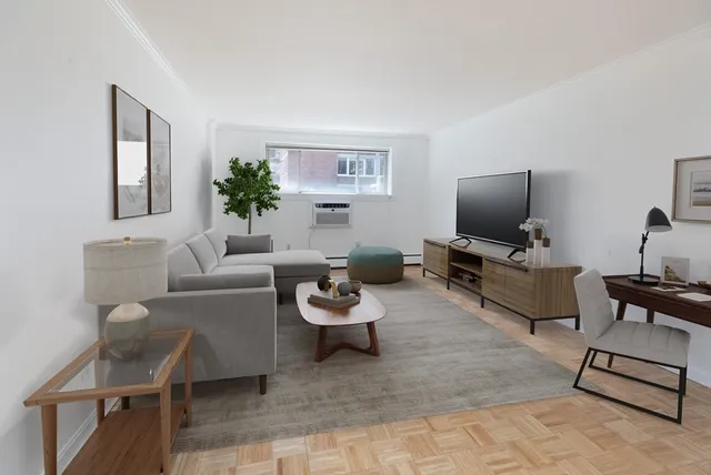 a living room with furniture a flat screen tv and a window