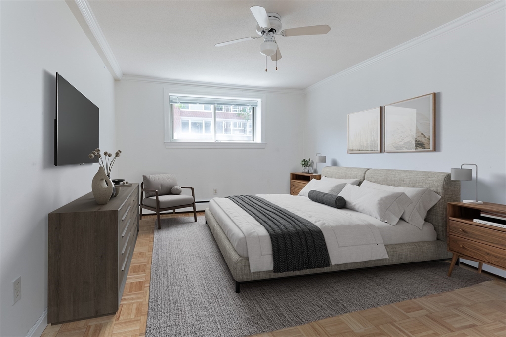 329 Harvard Street, Unit 1 Cambridge, MA 02139 - Photo 5 of 8 a spacious bedroom with a bed and a flat screen tv