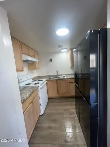 a large kitchen with stainless steel appliances granite countertop a stove a sink and a refrigerator