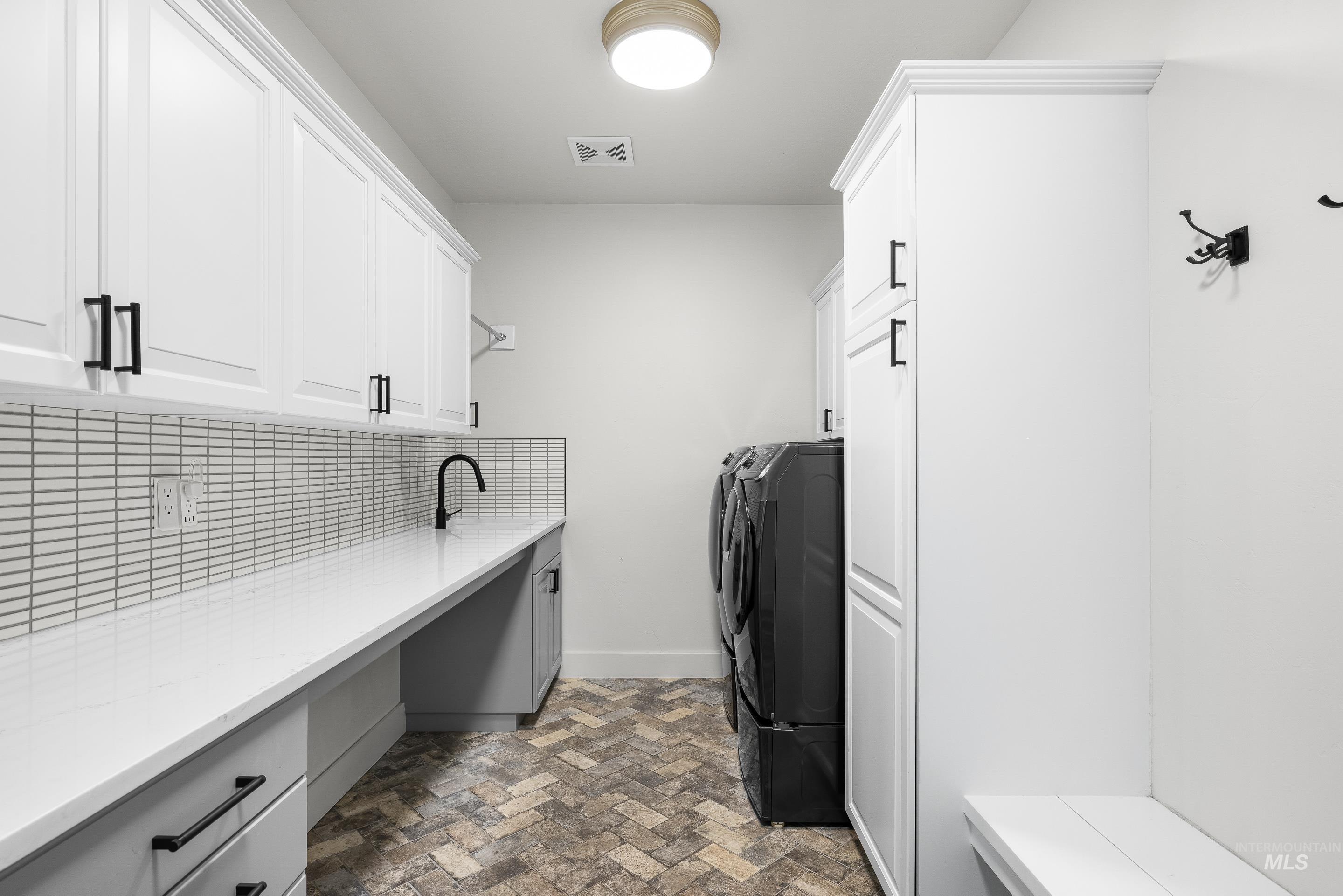 1166 East Rivers End Drive Eagle, ID 83616 - Photo 41 of 50 Laundry room featuring brick patterned flooring, washer and clothes dryer, and cabinet space