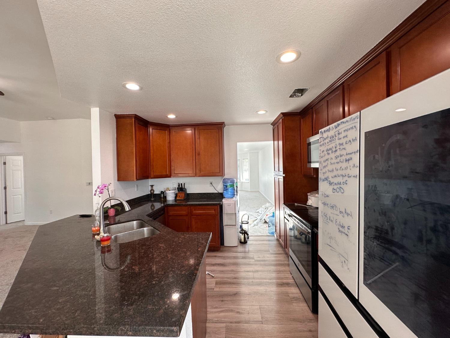 911 Toro Lane Lathrop, CA 95330 - Photo 8 of 36 Spacious kitchen featuring rich wood cabinetry, Granite countertops, and a double basin sink with a high-arc faucet, recessed lights