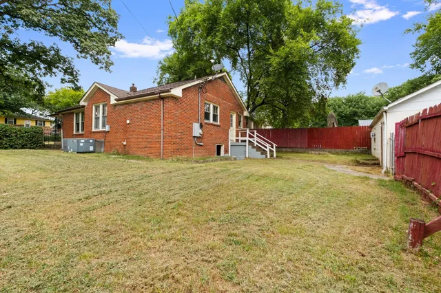 a view of an house with backyard space and tree
