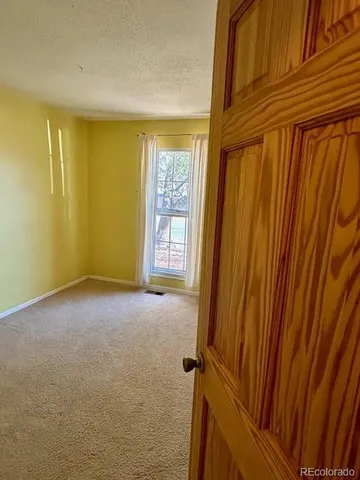 an empty room with wooden floor and door