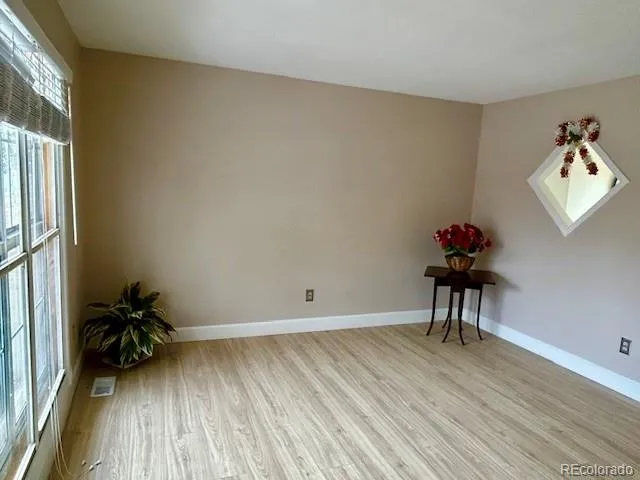 a view of a room with wooden floor and a potted plant