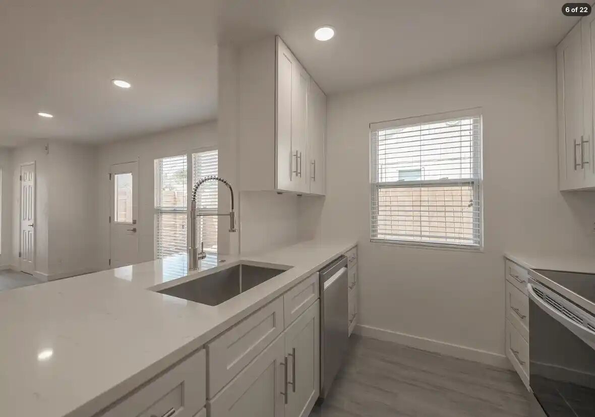 303 Fantail Loop, Unit B Austin, TX 78734 - Photo 2 of 11 Gleaming stone countertops and modern cabinetry elevate this open-concept kitchen.