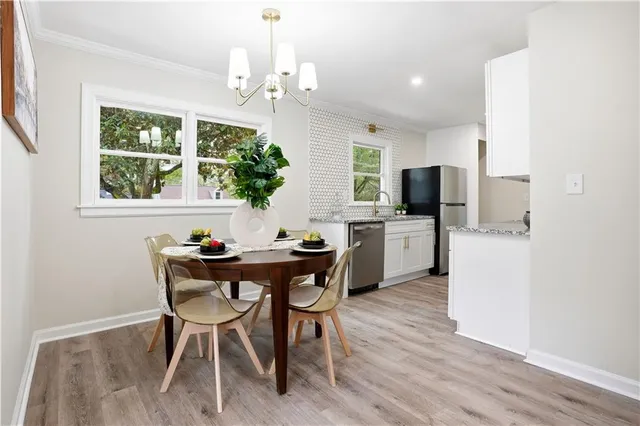 a dining room with furniture a potted plant and a chandelier