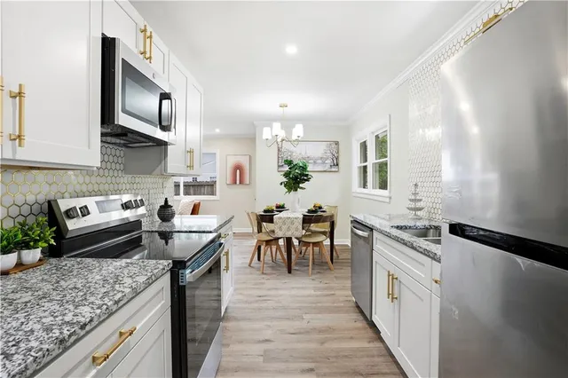 a kitchen with stainless steel appliances granite countertop a refrigerator and a stove top oven