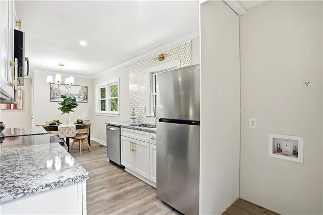 a kitchen with granite countertop stainless steel appliances a sink a stove top oven a counter space and cabinets