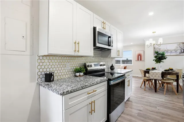 a dining room with furniture a chandelier and wooden floor