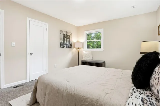 a bedroom with a bed and a painting on the wall