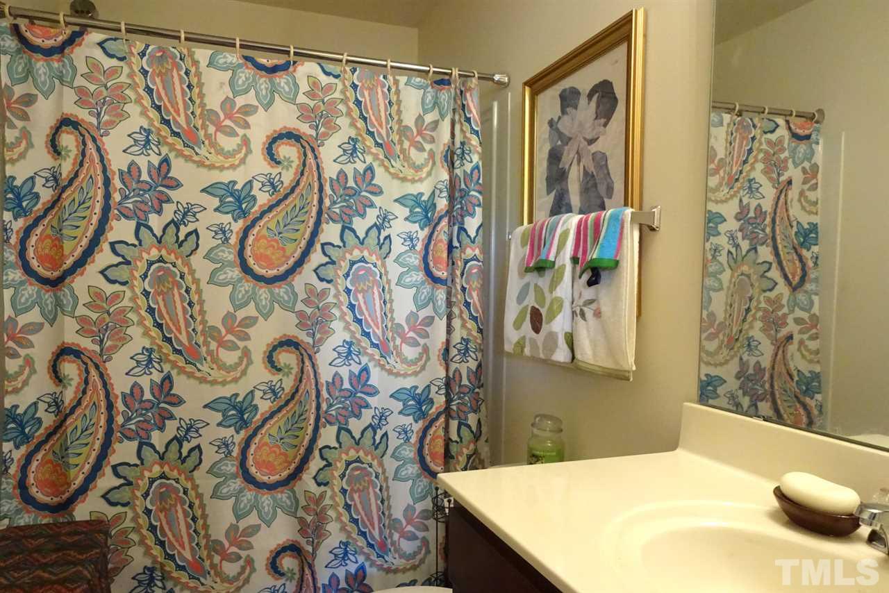 2938 Berkeley Springs Place Raleigh, NC 27616 - Photo 14 of 19 a bathroom with a bathtub and shower curtain