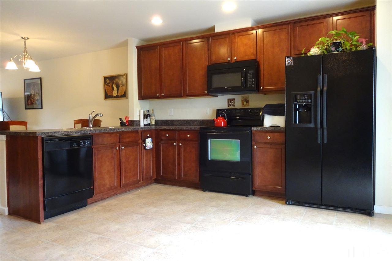 2938 Berkeley Springs Place Raleigh, NC 27616 - Photo 7 of 19 a kitchen with stainless steel appliances granite countertop a refrigerator a stove a sink and a microwave
