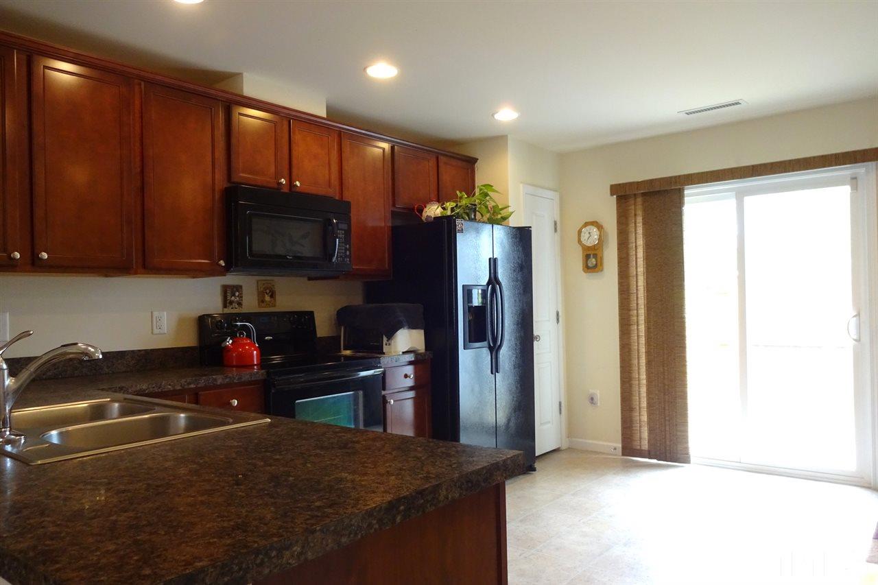 2938 Berkeley Springs Place Raleigh, NC 27616 - Photo 8 of 19 a kitchen with stainless steel appliances granite countertop a refrigerator and a stove top oven