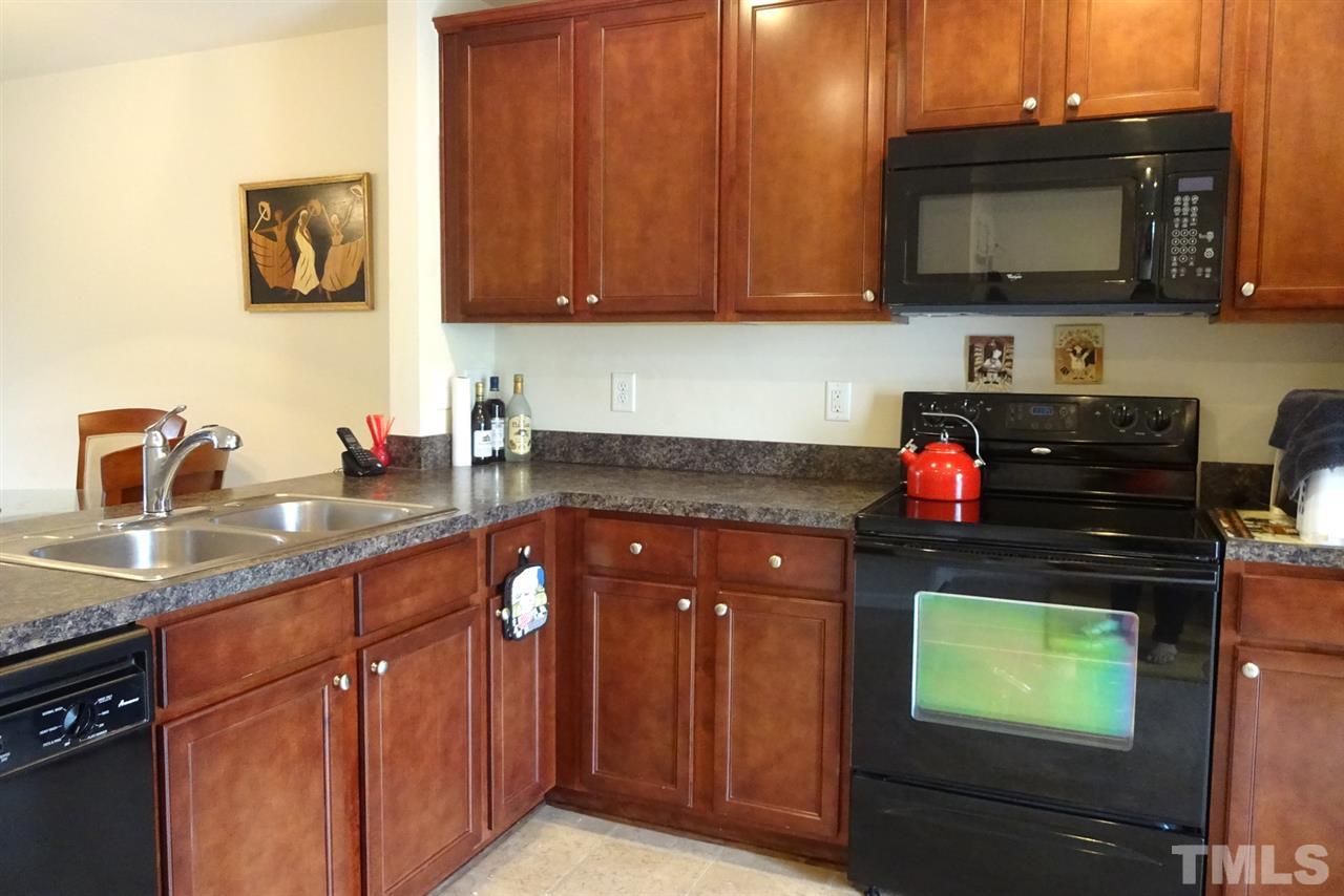 2938 Berkeley Springs Place Raleigh, NC 27616 - Photo 9 of 19 a kitchen with stainless steel appliances granite countertop a stove a sink and a microwave