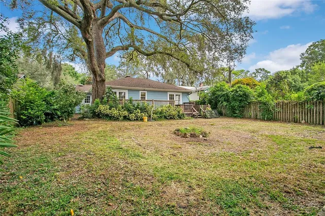 a view of house with yard and trees in the background
