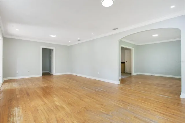 a view of an empty room with wooden floor and closet