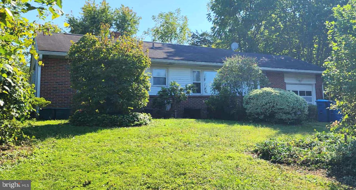 a view of a house with a yard and potted plants