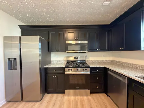 a kitchen with a sink stove and refrigerator