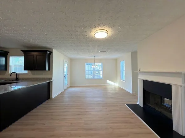 a view of empty room with a kitchen and fireplace