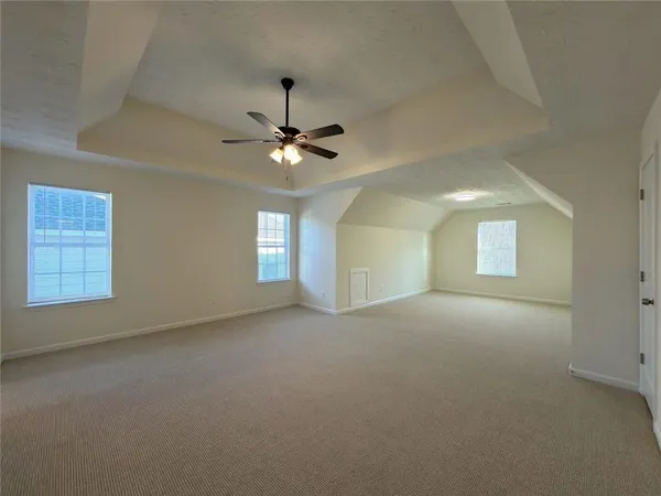 a view of a room with windows and ceiling fan
