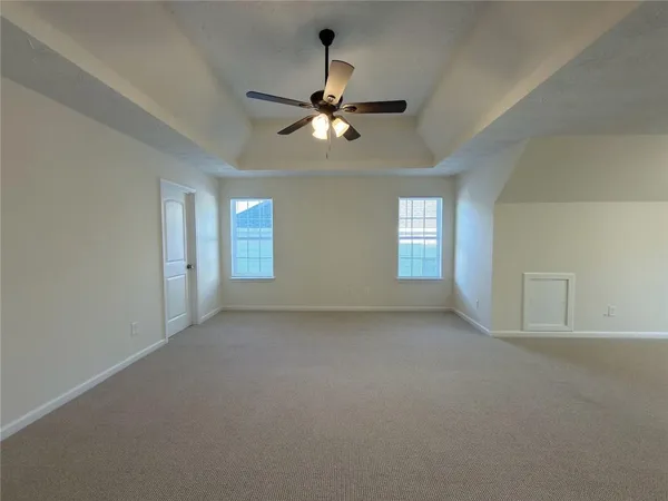 an empty room with ceiling fan and window