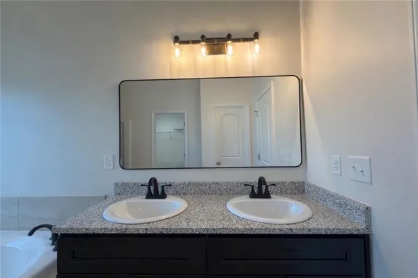 a bathroom with double sink and a mirror