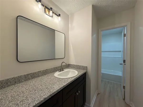 a bathroom with a granite countertop sink and mirror