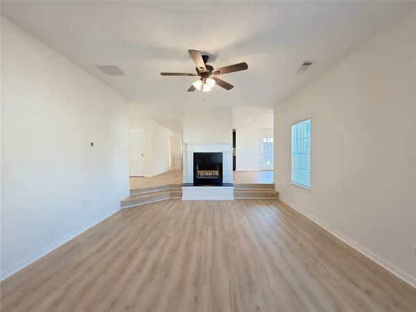 wooden floor in an empty room with a window