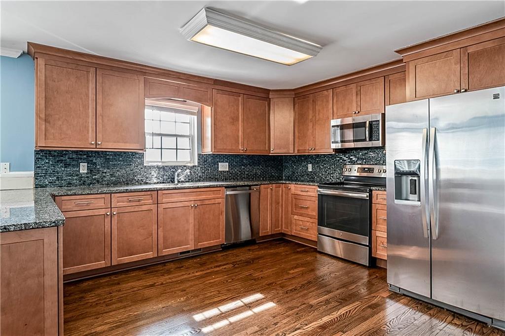 2670 Old Jackson Road Locust Grove, GA 30248 - Photo 18 of 30 a kitchen with granite countertop wooden cabinets a refrigerator and a sink
