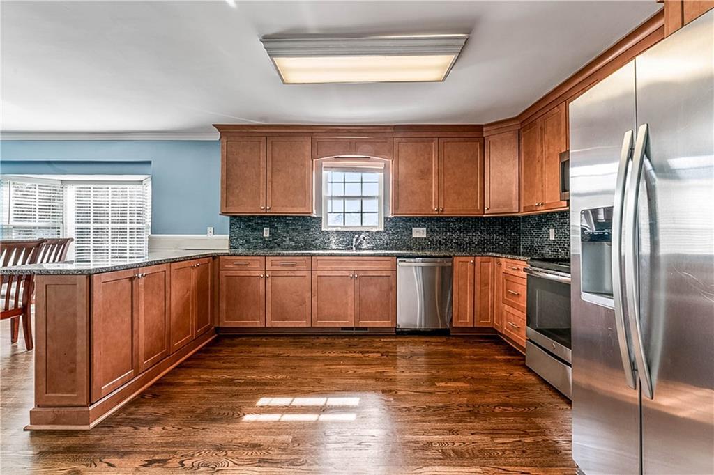 2670 Old Jackson Road Locust Grove, GA 30248 - Photo 19 of 30 a kitchen with granite countertop a refrigerator and wooden cabinets