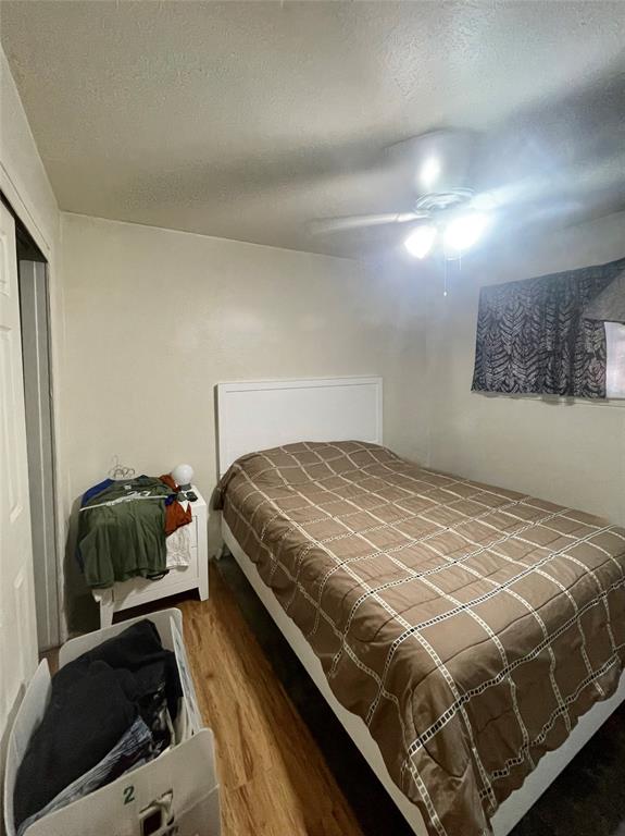 3525 Colonial Avenue Dallas, TX 75215 - Photo 7 of 24 Bedroom featuring wood finished floors, a closet, a textured ceiling, and ceiling fan