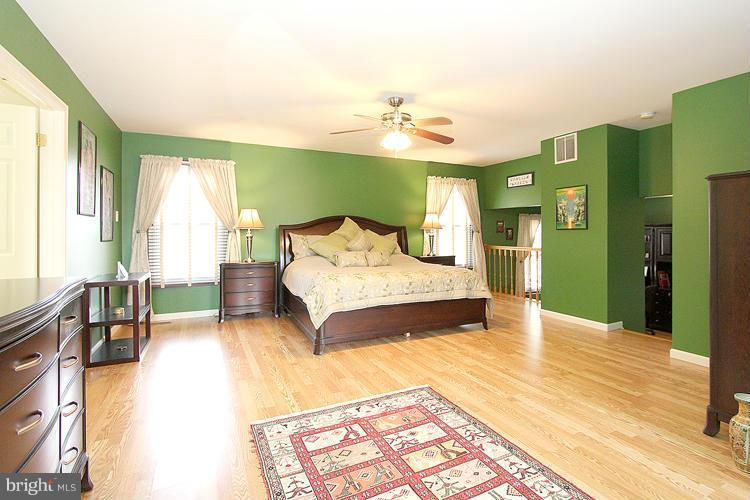 1840 Middlebridge Drive Silver Spring, MD 20906 - Photo 15 of 25 a spacious bedroom with a bed and a chandelier
