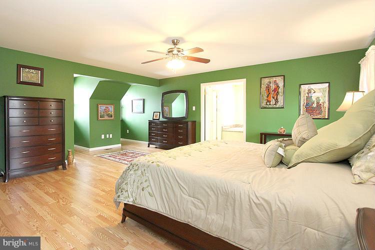 1840 Middlebridge Drive Silver Spring, MD 20906 - Photo 16 of 25 a bedroom with a bed and a chandelier