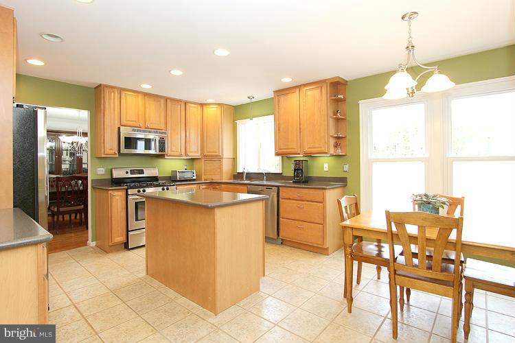 1840 Middlebridge Drive Silver Spring, MD 20906 - Photo 6 of 25 a kitchen with stainless steel appliances granite countertop a stove top oven a sink a dining table and chairs