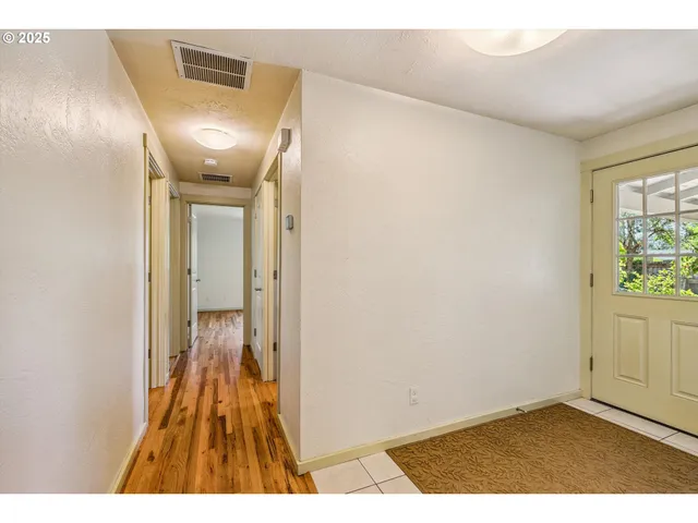 an empty room with wooden floor and window